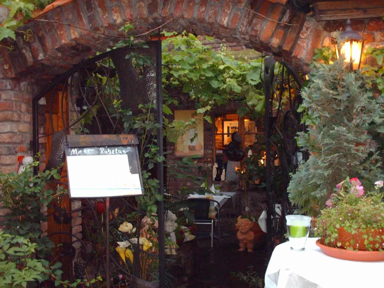 Eingang Château d'Orsay – schmiedeeiserner Torbogen mit Weinreben und historischem Backsteinbogen