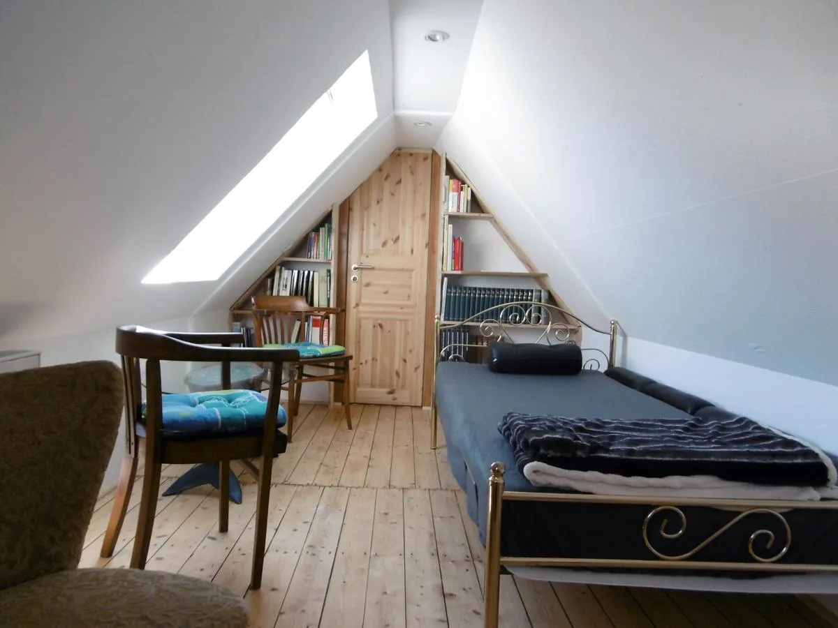 Dachschrägen-Zimmer mit Bibliothek, Messingbett und Dachfenster