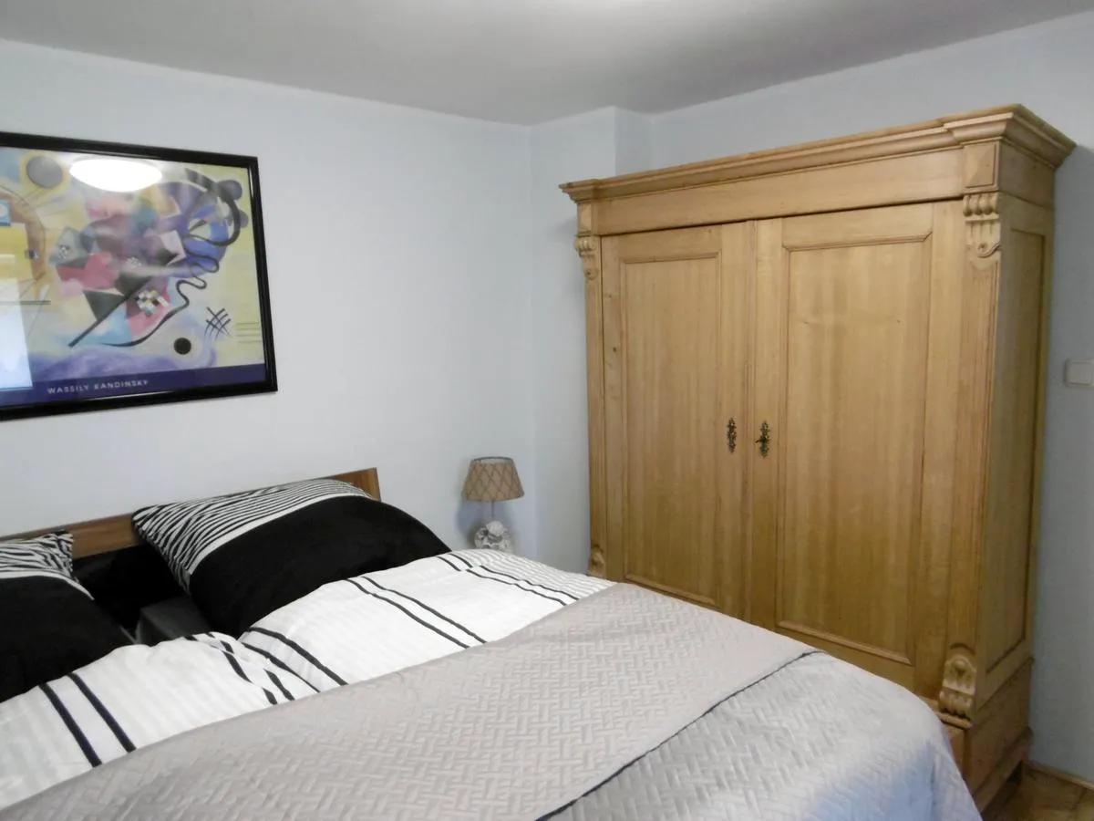 Zweites Schlafzimmer mit antikem Kleiderschrank und Kandinsky-Druck